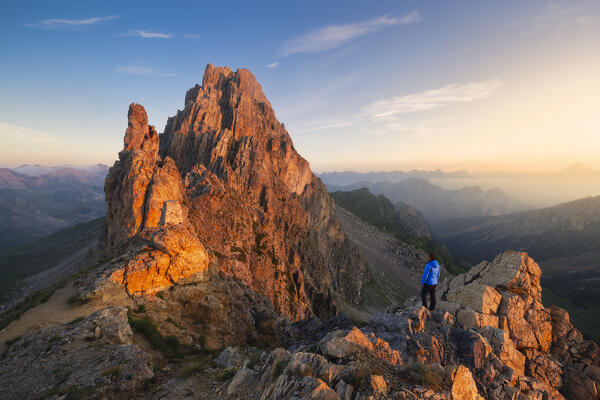 A trekker at Colletto della Meja in front of Rocca la Meja at sunrise, Maira Valley, Canosio, Cuneo, Piedmont, Italy, Southern Europe (MR)