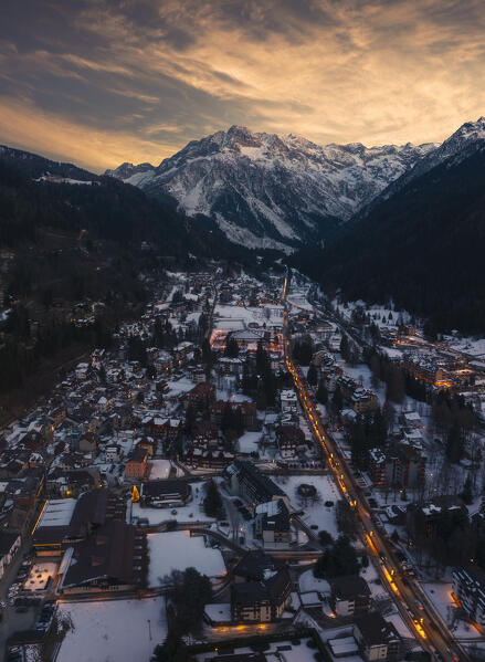 Aerial view of illuminated Ponte di Legno at dusk with mountains and Punta Castellaccio in the background during winter, Ponte di Legno, Brescia, Lombardia, Italy, Southern Europe