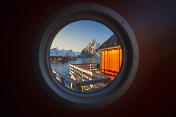 The view of the bay through a porthole of a rorbu door in Hamnoy with the, Hamnoy, Moskenes, Moskenesoya, Nordland, Lofoten, Norway, Northern Europe