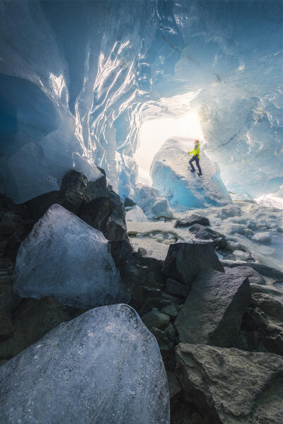 A trekker inside an ice cave of Morteratsch glacier during winter, Bernina Valley, Grigioni, Switzerland, Western Europe