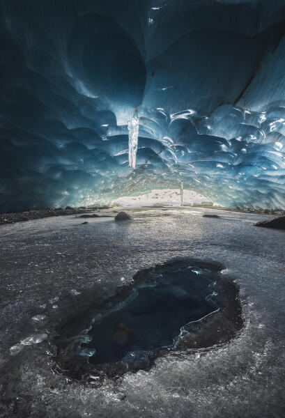 An hole in the ice inside ice cave of Morteratsch glacier during winter, Bernina Valley, Grigioni, Switzerland, Western Europe