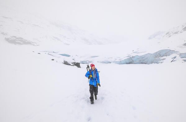 A trekker walks in the snow at Morteratsch glacier during winter, Bernina Valley, Grigioni, Switzerland, Western Europe