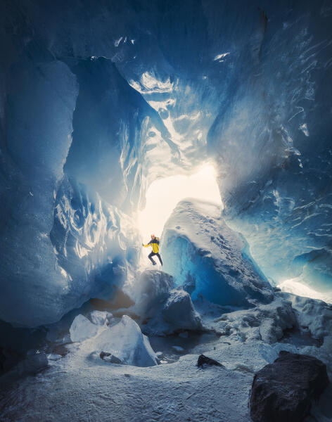 A trekker inside an ice cave of Morteratsch glacier during winter, Bernina Valley, Grigioni, Switzerland, Western Europe