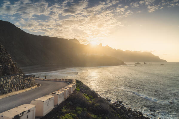 A tourist walks along the road to Almaciga and Anaga mountains during sunset, Benijo, Santa Cruz de Tenerife, Tenerife, Canary Islands, Macaronesia, Spain, Western Europe