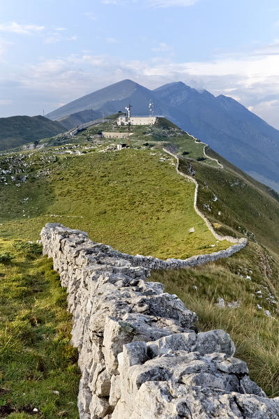 Ancient wall to fence the pastures on the Naole ridge. On the top of the mountain: the Italian fort of Naole. Mount Baldo, Verona province, Veneto, Italy, Europe.