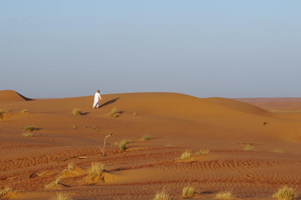 An omani man on sand dunes, Wahiba Sands desert, Oman. 