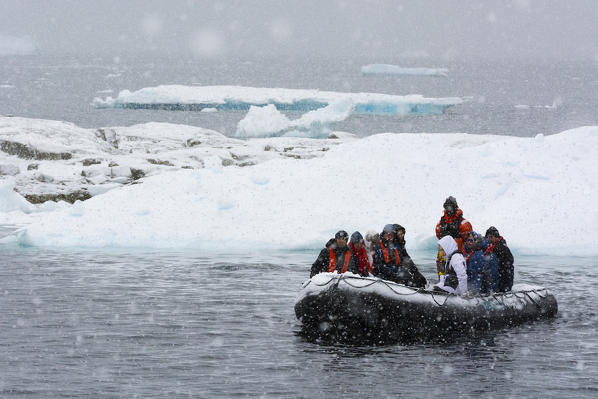A snowstorm hits tourists on an inflatable boat in Portal Point, Antarctica.
