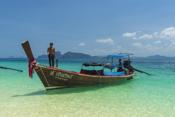 A long tailed boat waiting for tourist on a sandy beach, Ko Kradan, Talay Trang archipelago, Thailand.