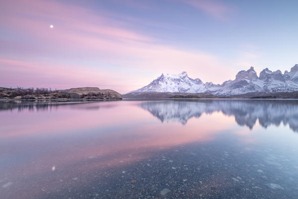Southern America, Chile, Patagonia, Torres del Paine National Park: the Torres and the Moon reflecting in the Pehoe Lake at sunrise