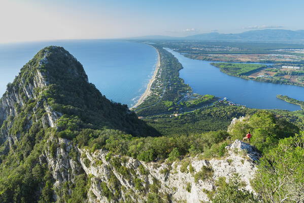 Rear view of a hiker admiring the view of the Paola lake and Sabaudia's beach on his route to the peak of Circeo mountain, San Felice Circeo, Circeo National Park, Pontine flats, Latina province, Latium, Central Italy, Italy, Southern Europe, Europe