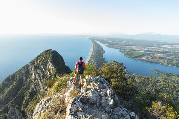 Rear view of a hiker admiring Paola lake and Sabaudia's beach on his route to the peak of Circeo mountain, San Felice Circeo, Circeo National Park, Pontine flats, Latina province, Latium, Central Italy, Italy, Southern Europe, Europe