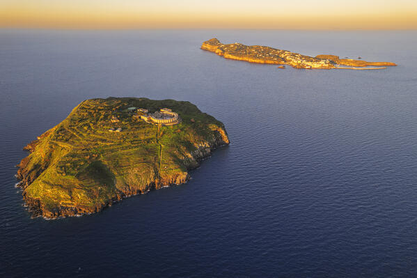Aerial view of the island of Santo Stefano with the old panopticon prison and Ventotene island in the background at sunrise, Santo stefano and Ventotene Islands, Pontine Islands archipelago, Tyrrhenian Sea, Latina province, Latium, Italy, Europe