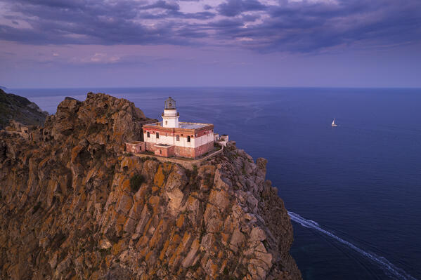 The Ponza's lighthouse on top of a volcanic cliff and surrounded by the sea at dusk, Ponza island, Pontine archipelago, Latina province, Latium region, Tyrrhenian Sea, Italy, Europe