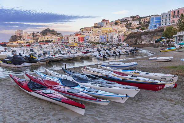 Canoes resting on sandy beach with boats surrounding the colorful houses of Ponza, Ponza island, Pontine islands, Tyrrhenian Sea, Latina province, Latium, Italy, Europe