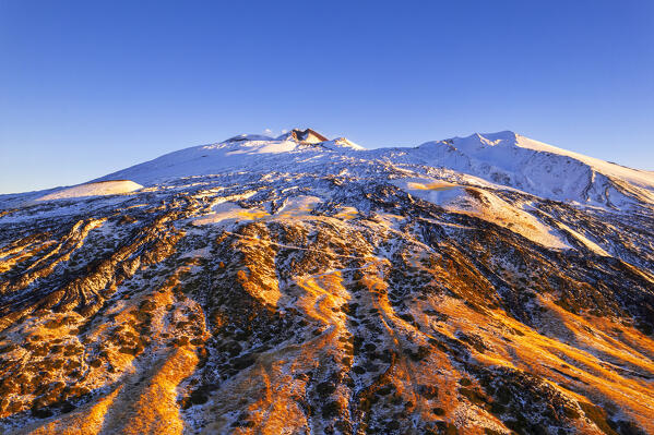 Drone winter view of snowy mount Etna with active summit crater in the background, sunrise time, Piano Vetore, Regalna, Catania province, UNESCO World heritage Site, Sicily, Mediterranean Sea, Southern Italy, Italy, Southern Europe, Europe