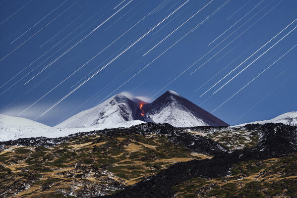 Star trail over summit crater of the Mount Etna during the eruption with the summit crater covered with snow, Piano Vetore, Regalna, Catania province, UNESCO World heritage Site, Sicily, Mediterranean Sea, Southern Italy, Italy, Southern Europe, Europe