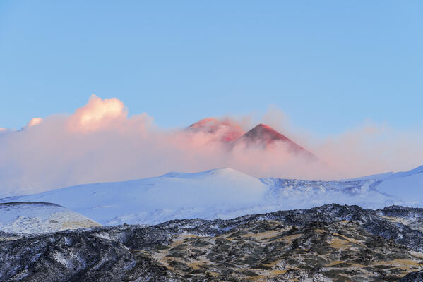 Sunrise view of the South-East crater of mount Etna appearing from the clouds in the winter volcanic landscape, Piano Vetore, Regalna, Catania province, UNESCO World heritage Site, Sicily, Mediterranean Sea, Southern Italy, Italy, Southern Europe, Europe