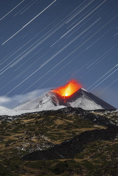 Star trail above the south-east crater of the snowy mount Etna during strombolian eruption with lava fountains, Piano Vetore, Regalna, Catania province, UNESCO World heritage Site, Sicily, Mediterranean Sea, Southern Italy, Italy, Southern Europe, Europe