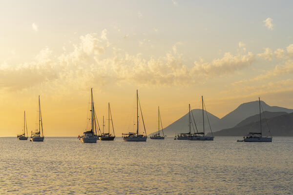 Sailing boats anchored in shallow water off the island of Vulcano at sunset, Vulcano island, Aeolian islands, Messina province, Sicily, Tyrrhenian Sea, Mediterranean Sea, South of Italy, Italy, Europe