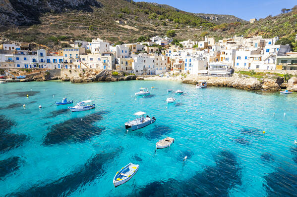 Aerial view of the white village of Levanzo with boats in the turquoise lagoon, Levanzo island, Favignana municipality, Trapani, Aegadian islands, Mediterranean Sea, Sicily, Italy