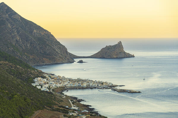 Traditional white fishing village of Marettimo with the castle (Punta Troia) on top of a cliff, sunset view, Marettimo island, Favignana municipality, Trapani, Aegadian islands, Mediterranean Sea, Sicily, Italy