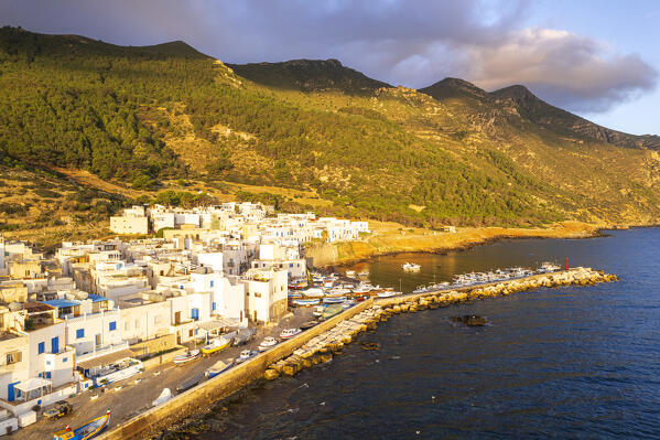 White-washed houses of the fishing village of Marettimo with the old harbour seen at sunrise, aerial view, Marettimo, Favignana municipality, Trapani, Aegadian islands, Mediterranean Sea, Sicily, Italy