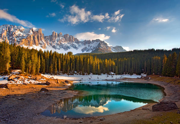 Dolomites. The Carezza lake, with fir forests and the Latemar ridge in the background, at sunset