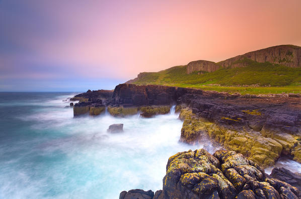 Isle of Skye,Scotland. Rocky cliffs and sea, with wooden hills, in the sunrise (Staffin bay, Skye island, Scotland)