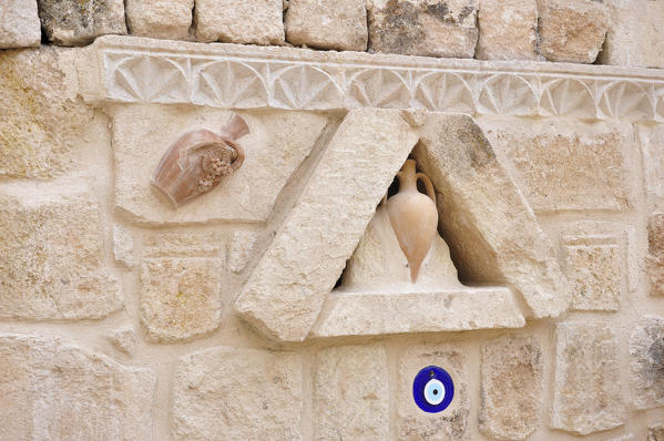 Typical sculpture on the wall on the old houses of Kappadokia region in Turkey. In these sculpture are represented the 'pottery' that are vases of terracotta and in blue color the Allah eye. The Allah eye has the aim to protect.