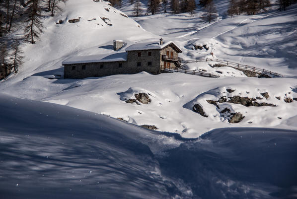 A mountain house is closed during the winter and it's surrounded by snow. Madeleine, Aosta Valley, Italy