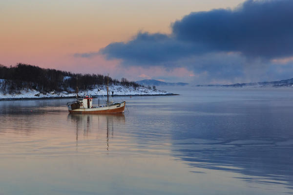 Fishing boat in the water near Silsand in winter, Senja, nordland, norway, europe