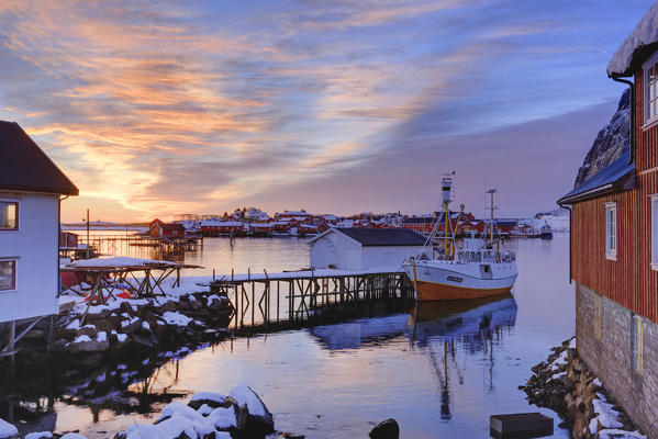 Fishing boat at a small fishing dock at Reine at sunrise in winter, lofoten islands, nordland, norway, europe