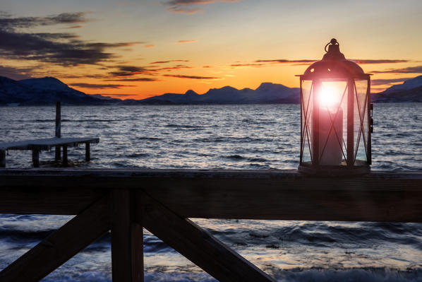 Oli lamp on a fence of a fishing cottage ad dawn on a fjord near Tromso, Troms, Norway, Europe