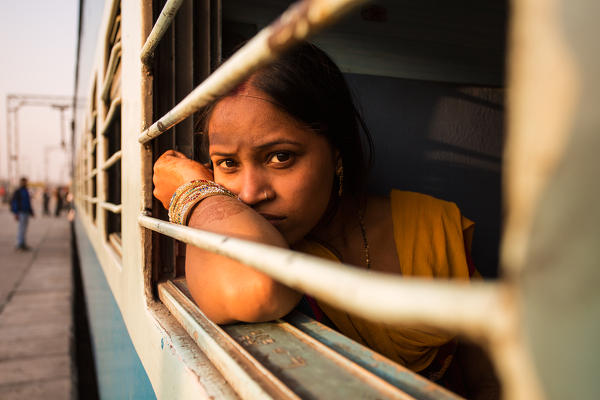 Asia, India, New Delhi. 
An Indian girl looking out the window train.