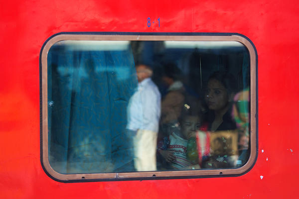 Mom with her son in the train stopped at the station of Delhi -India .