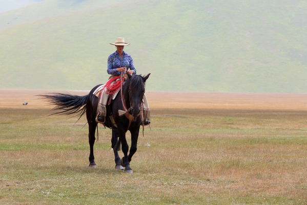 Europe,Italy,Umbria,Perugia district,Castelluccio of Norcia. Woman riding