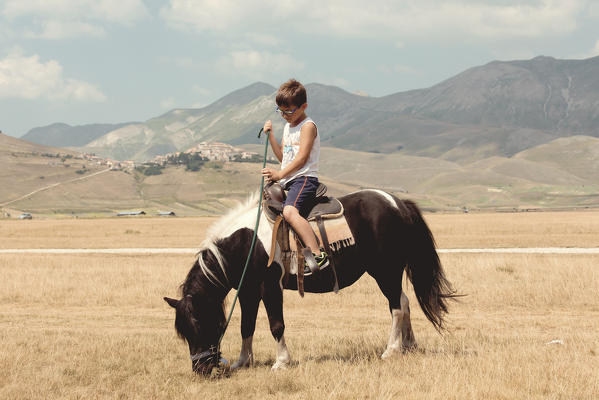 Europe, Italy,Umbria,Perugia district,Castelluccio of Norcia.
Child riding a Pony