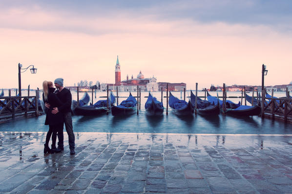 Europe,Italy,Veneto,Venice.
A young couple and gondolas at Riva degli Schiavoni