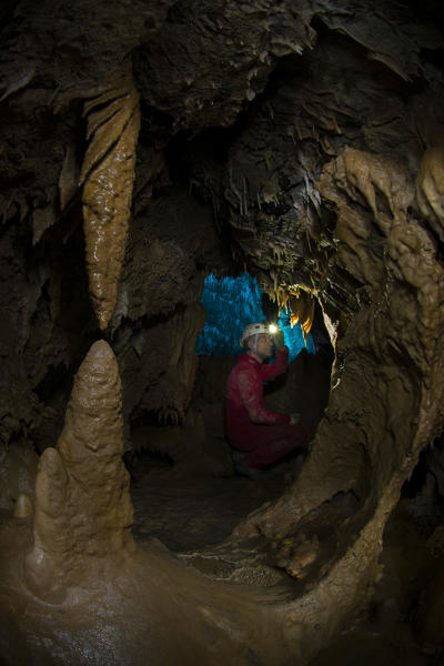 Speleologist in a ligurian cave looking for concrections