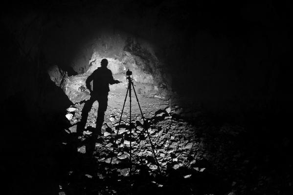 Speleologist exploring an italian cave here in backlight