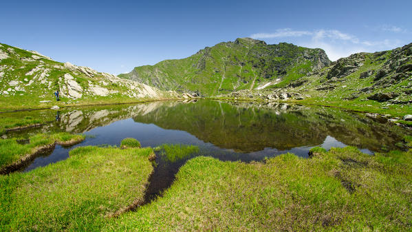 An alpine lake with the reflex of Mount Marzo, seen in summer.