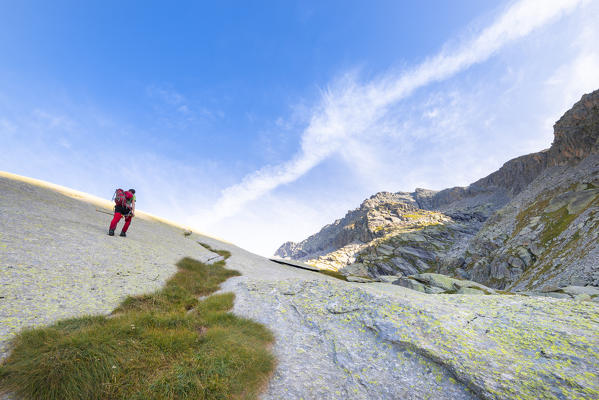 Hikers on smoothed rocks, Eugio valley, Locana, Orco Valley, Gran Paradiso National Park, Piedmont, Italian alps, Italy