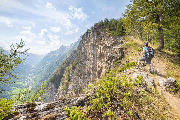Hiker on a cliff, Plan Cou, Val di Rhemes, Gran Paradiso National Park, Vallee d Aoste, Italian alps, Italy