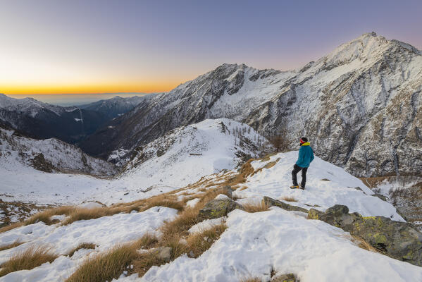 Alpinist looks to the sunrise, Campiglia Valley, Valle Soana, Gran Paradiso National Park, Piedmont, Province of Turin, Italian alps, Italy
