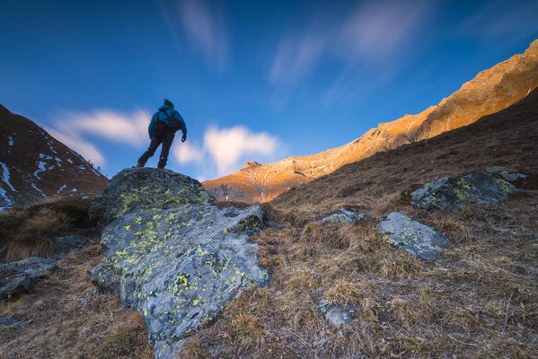 Hiker at dusk under Rosa dei Banchi, Valle Soana, Gran Paradiso National Park, Piedmont, Italy, Italian alps