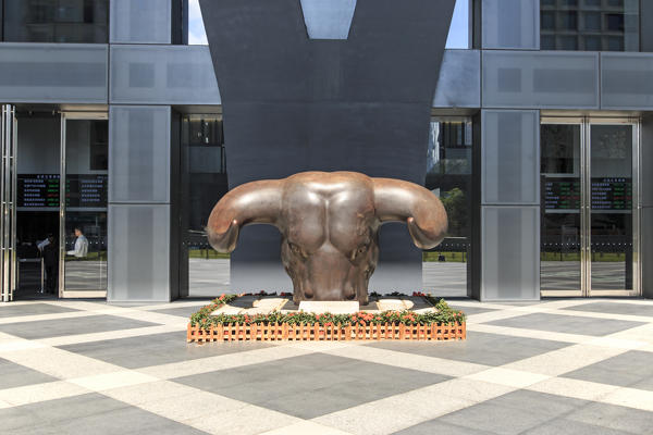 Stock market building in Shenzhen, one of the three stock markets in China, with the copper bull statue on foreground. The others two Stock Markets of China are in Hong Kong and Shanghai.