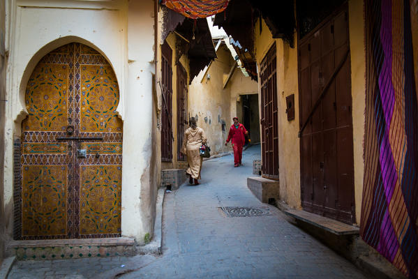 Fes, Morocco, North Africa. Passers in the narrow streets of the medina.