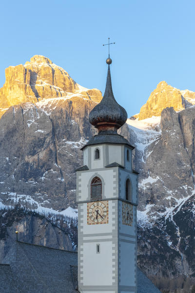 Colfosco, Alta Badia, Dolomites, South Tyrol, Italy. Thebell tower of the church San Vigilio with the Sella group in background