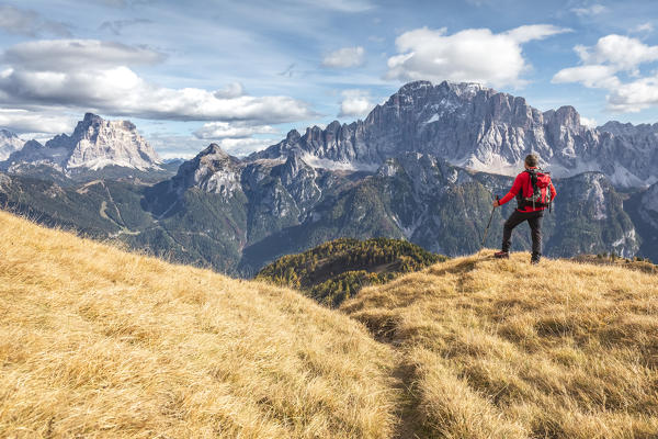 Hiker looking to the Civetta and Pelmo mountains from the path to Sasso Bianco, Agordino, Belluno, Veneto, Italy
