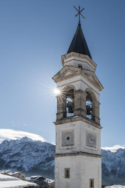 Costalissoio, municipality of Santo Stefano di Cadore, detail of the bell tower of the church of Holy Trinity in winter, Belluno, Veneto, Italy